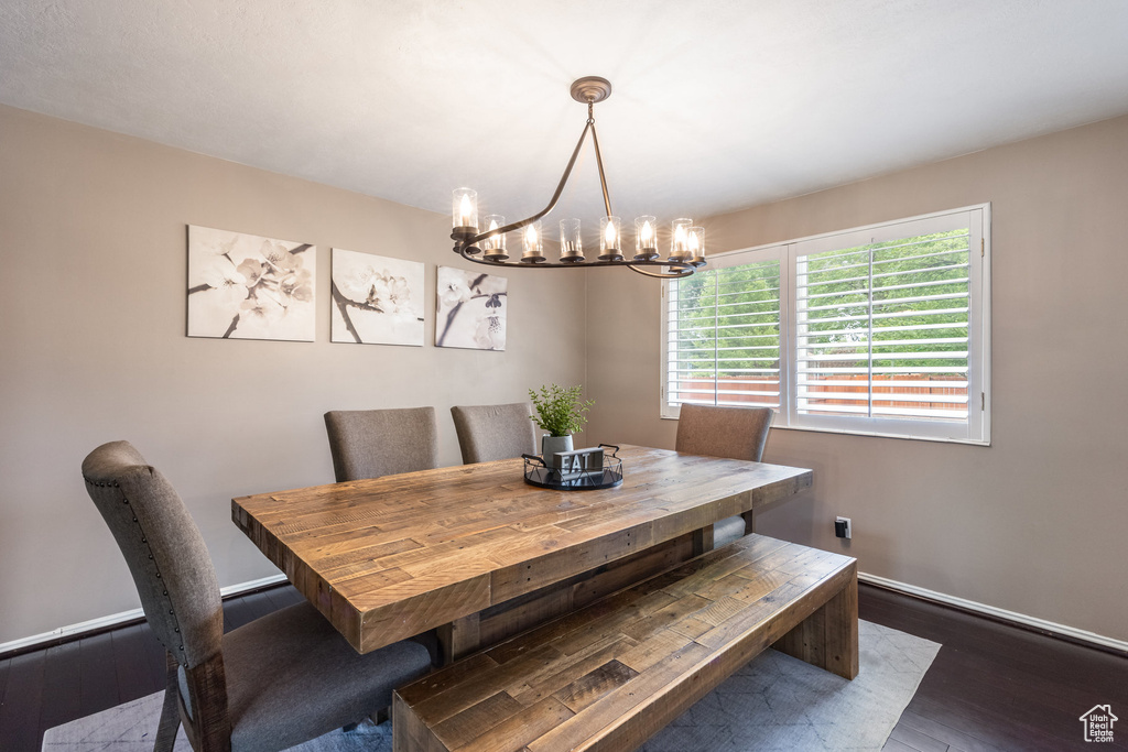 Dining area featuring a chandelier, wood finished floors, and baseboards