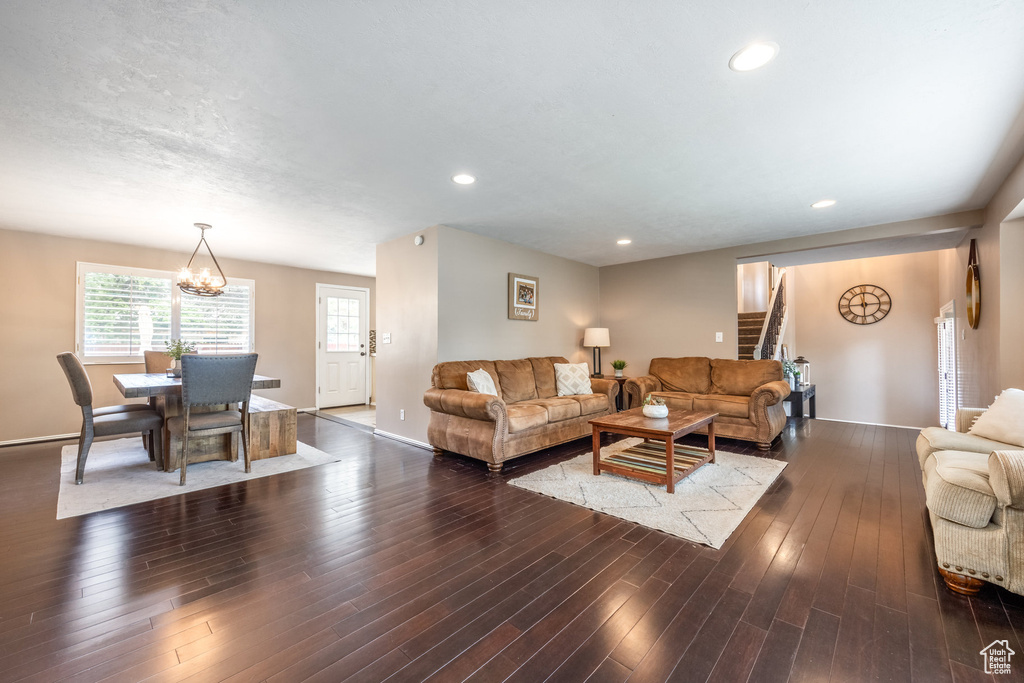 Living area with stairs, a chandelier, wood finished floors, and recessed lighting