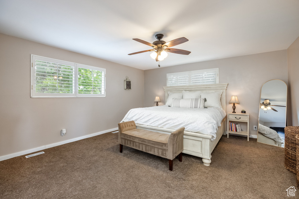 Carpeted bedroom with baseboards and a ceiling fan