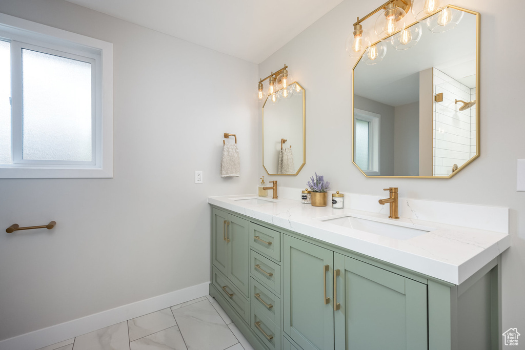 Bathroom with plenty of natural light, baseboards, marble finish flooring, and double vanity