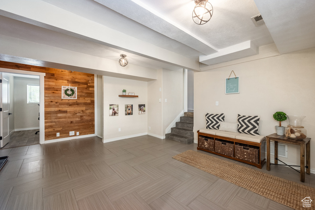 Entrance foyer featuring stairway, baseboards, and wooden walls