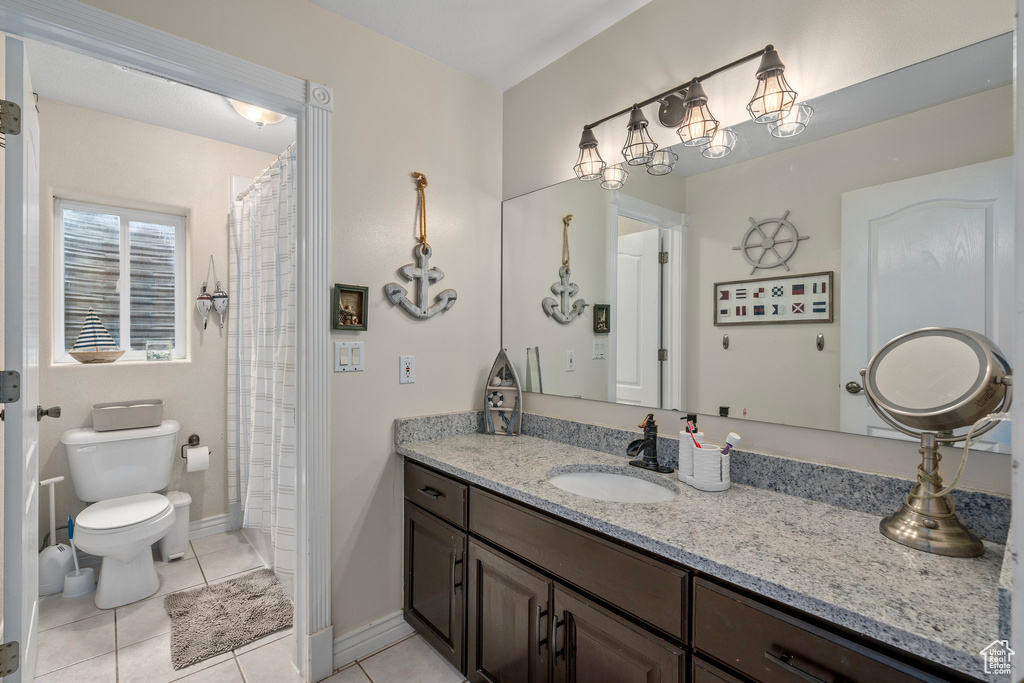 Full bath with tile patterned flooring, toilet, vanity, baseboards, and a shower with curtain