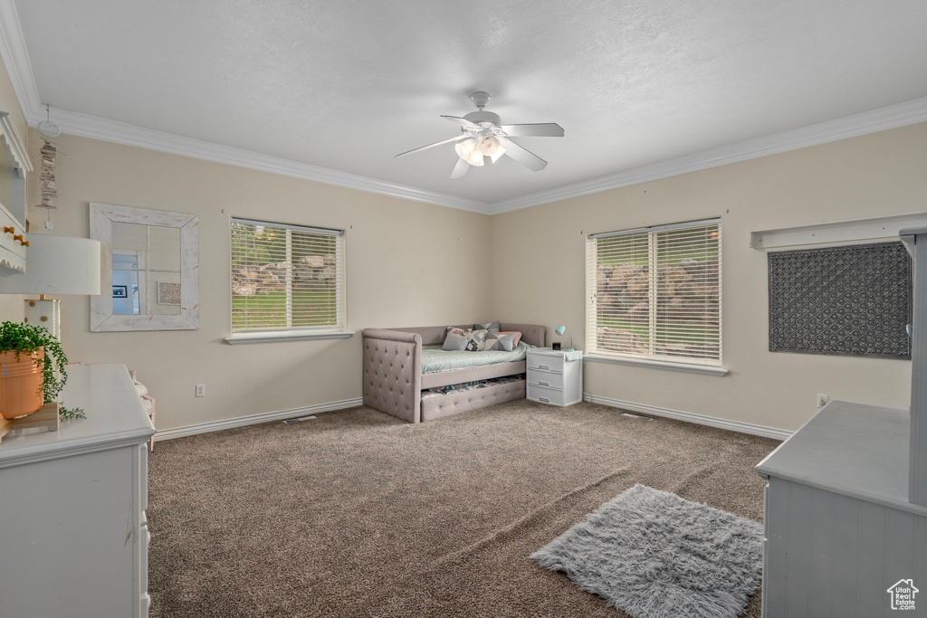 Carpeted bedroom with ornamental molding, baseboards, and a ceiling fan