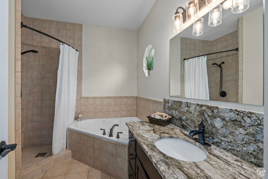 Bathroom with a shower stall, a garden tub, tile patterned floors, and vanity