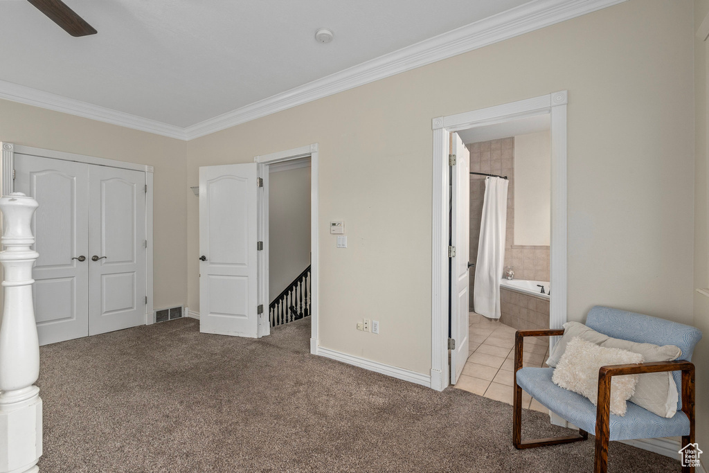 Bedroom featuring crown molding, carpet, baseboards, a closet, and ensuite bath