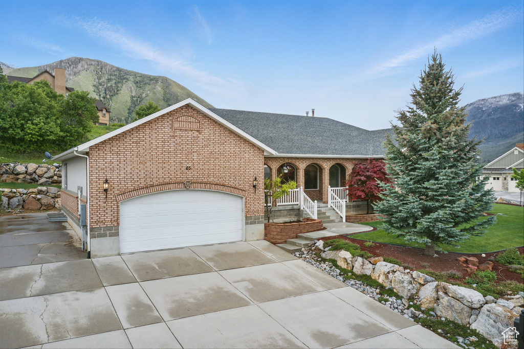 View of front of property featuring brick siding, an attached garage, concrete driveway, roof with shingles, and a porch