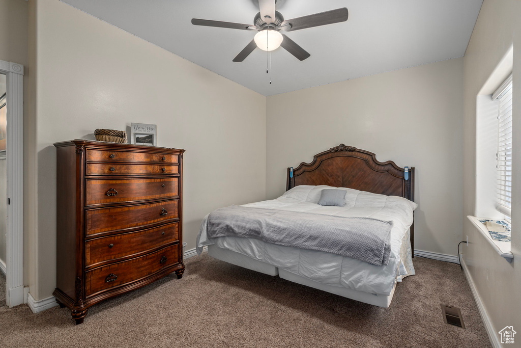 Carpeted bedroom with baseboards and a ceiling fan