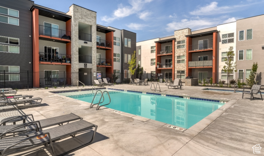 Community pool with a patio area and fence