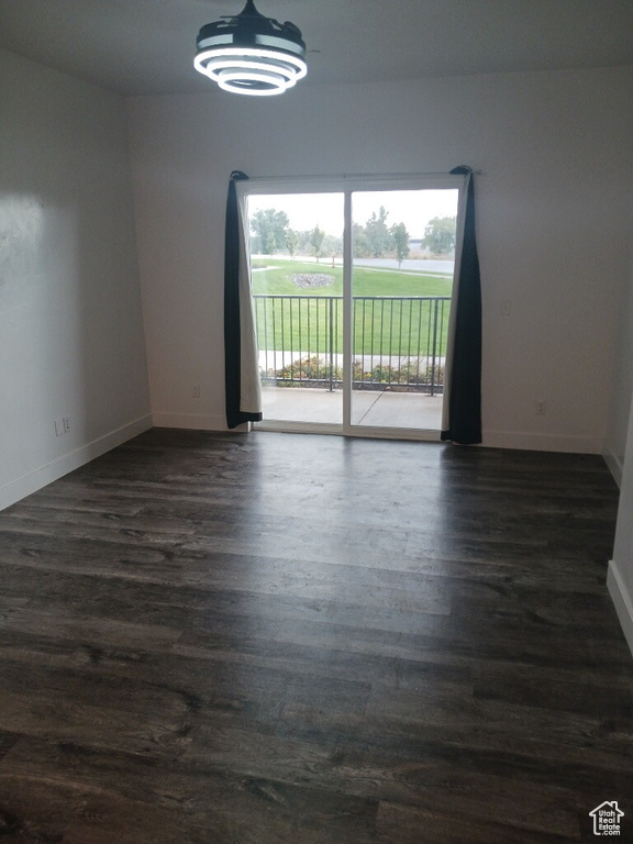 Spare room featuring plenty of natural light, dark wood finished floors, and baseboards