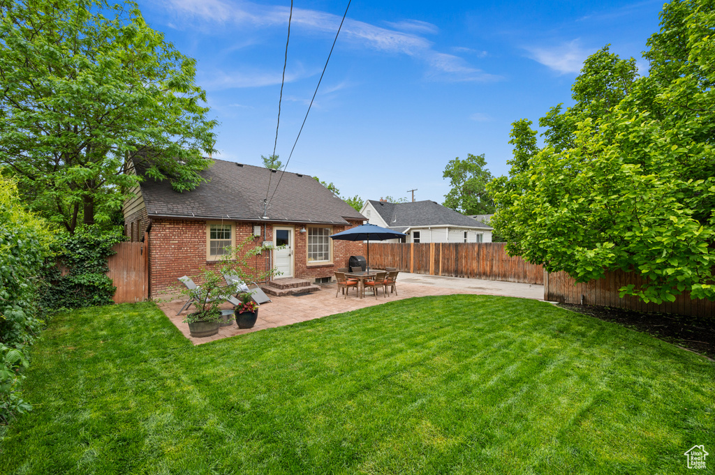 Back of house featuring brick siding, a patio area, roof with shingles, and entry steps