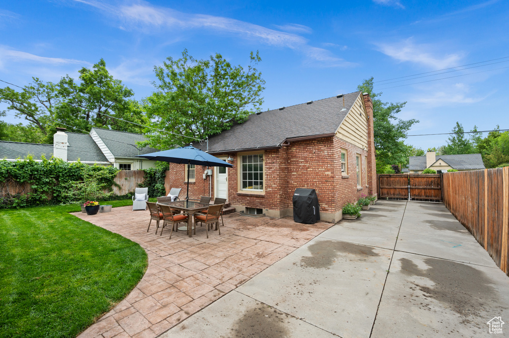 Back of property with brick siding, a patio, and roof with shingles