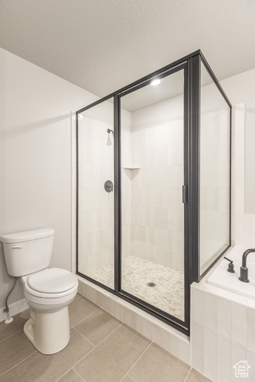 Bathroom with a garden tub, a shower stall, and tile patterned floors