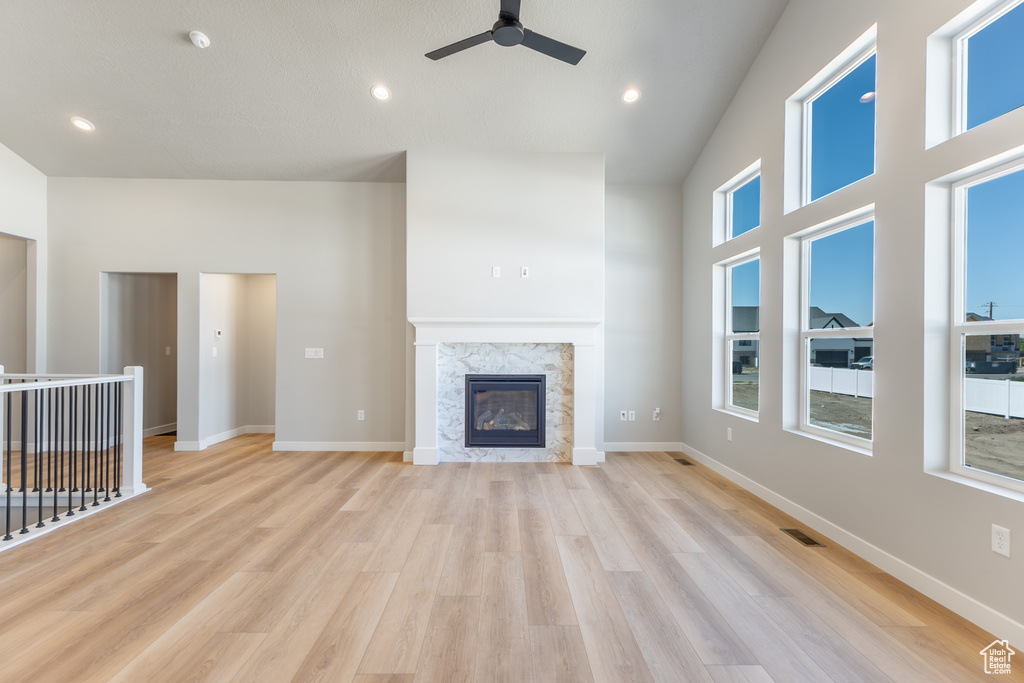 Unfurnished living room with ceiling fan, light wood-style flooring, a fireplace, and recessed lighting