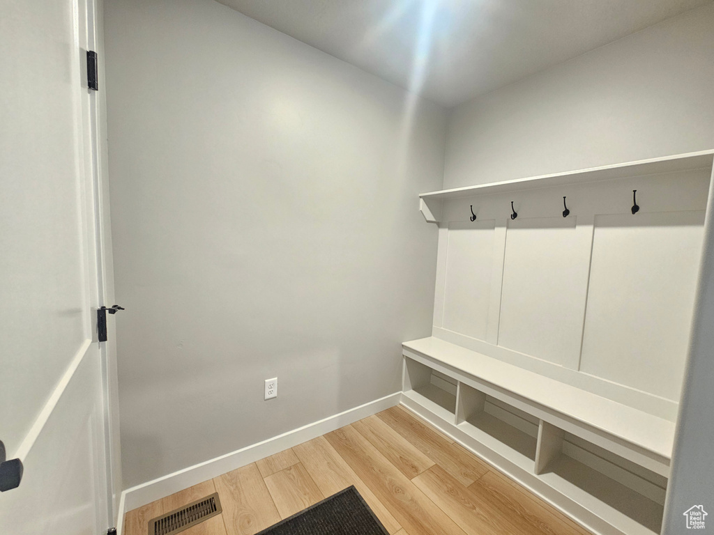 Mudroom featuring light wood finished floors and baseboards