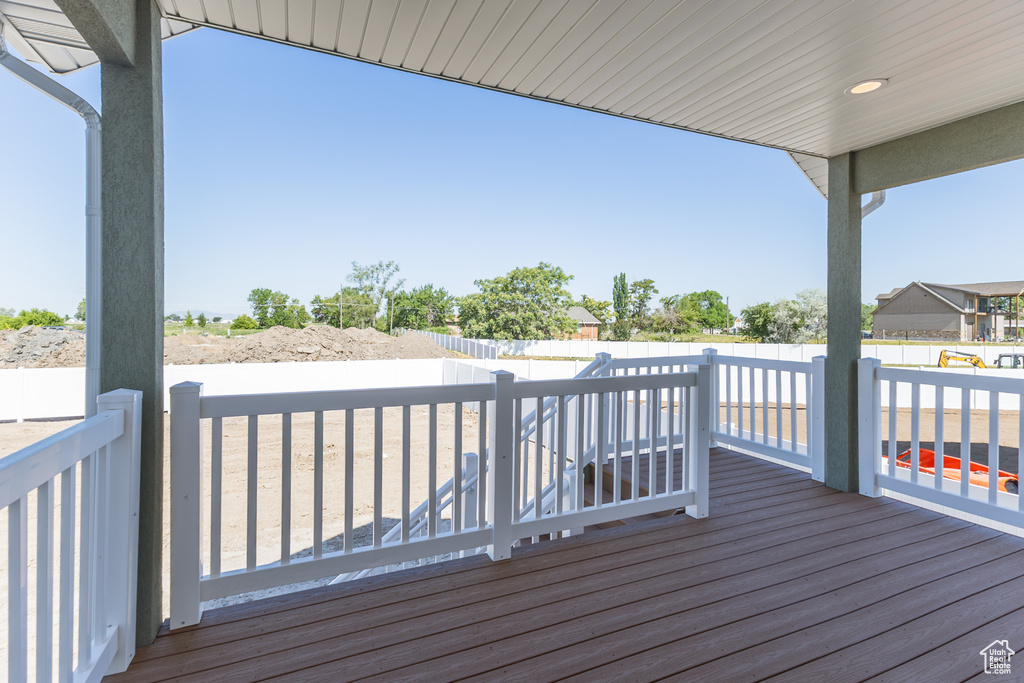 Wooden terrace with a fenced backyard