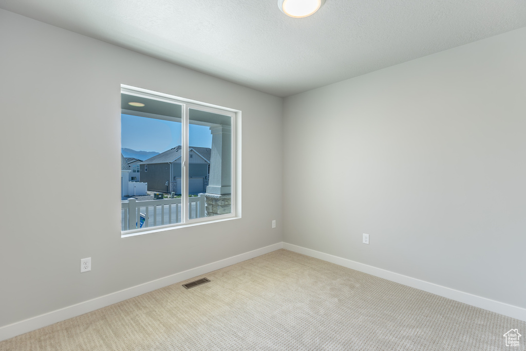 Carpeted empty room featuring baseboards