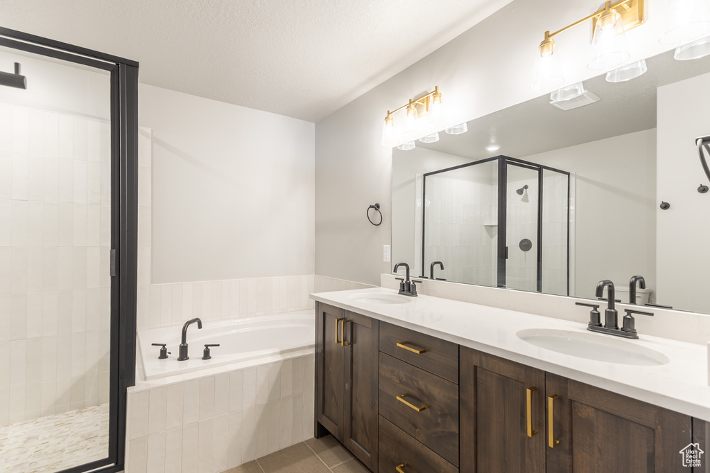 Full bath with a bath, double vanity, a shower stall, and tile patterned flooring