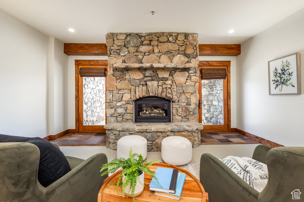 Living room with baseboards, a stone fireplace, and recessed lighting