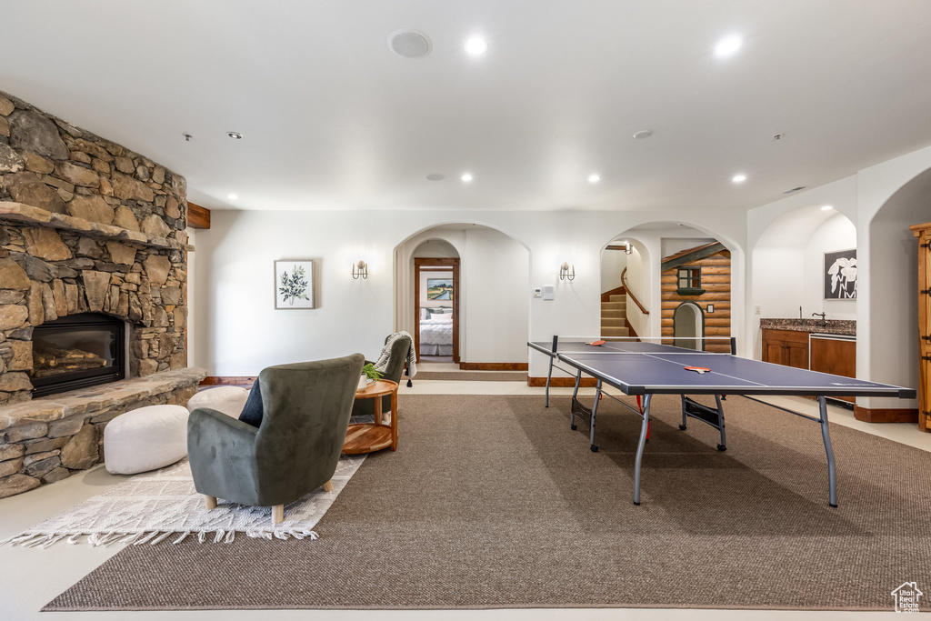 Game room with recessed lighting, a stone fireplace, and arched walkways