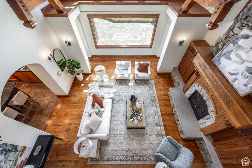 Living room featuring wood finished floors, a fireplace, and arched walkways