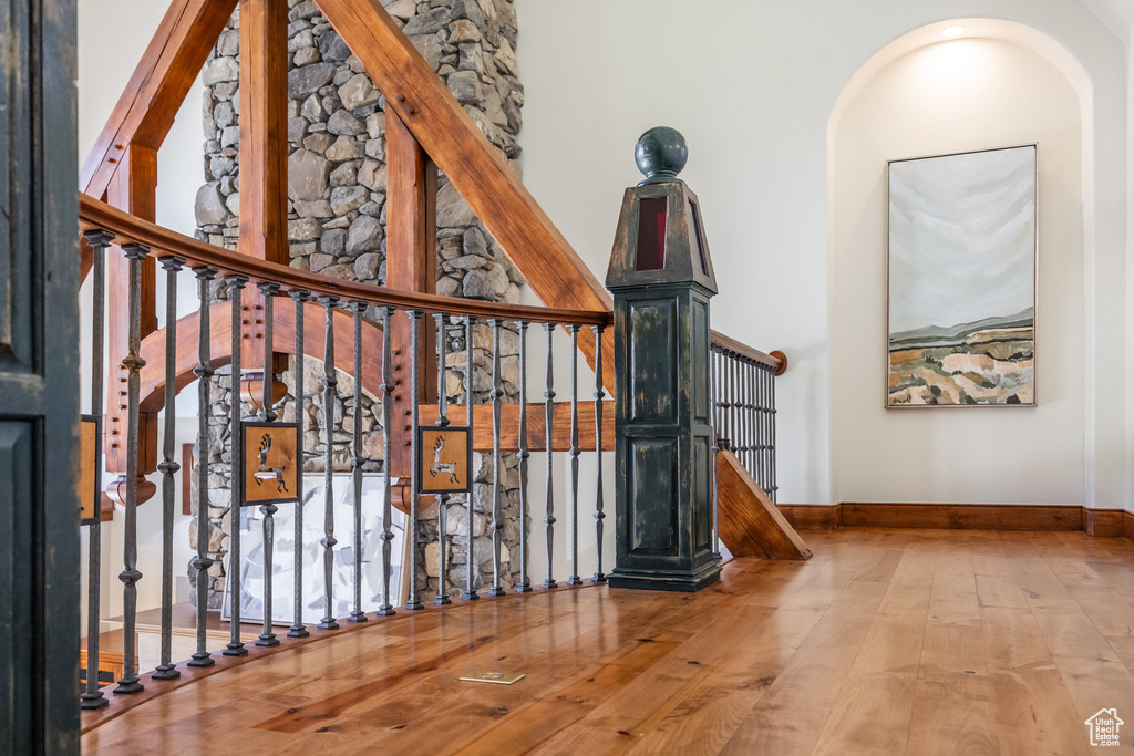 Stairway with hardwood / wood-style floors, baseboards, and a towering ceiling