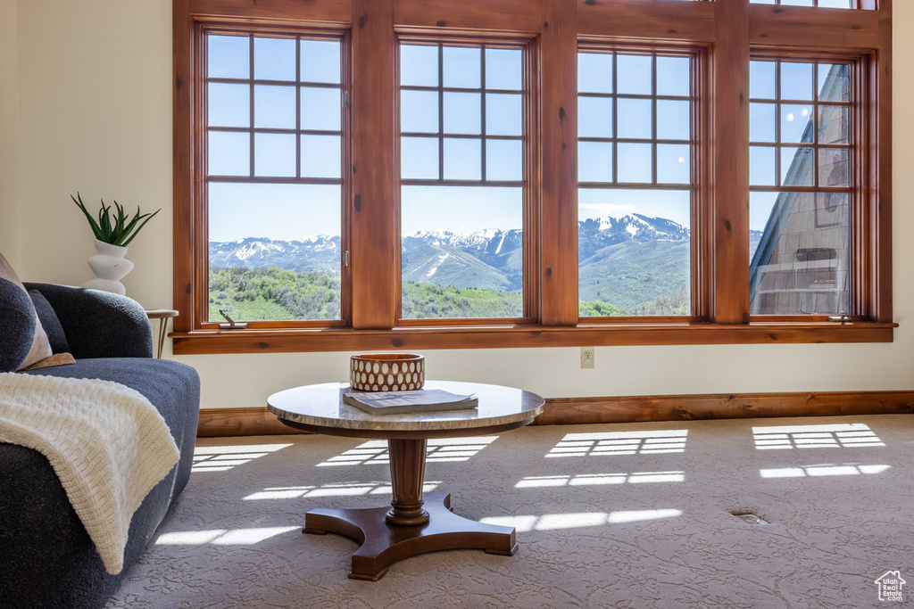 Living area with healthy amount of natural light, a mountain view, and baseboards
