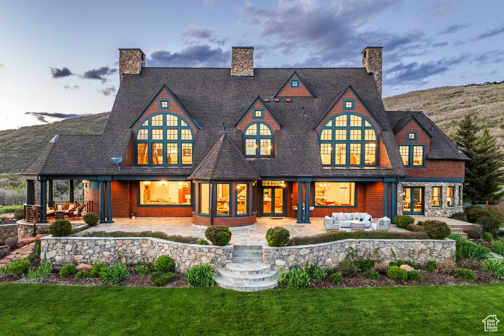 Rear view of house featuring french doors, an outdoor living space, a patio, and a yard