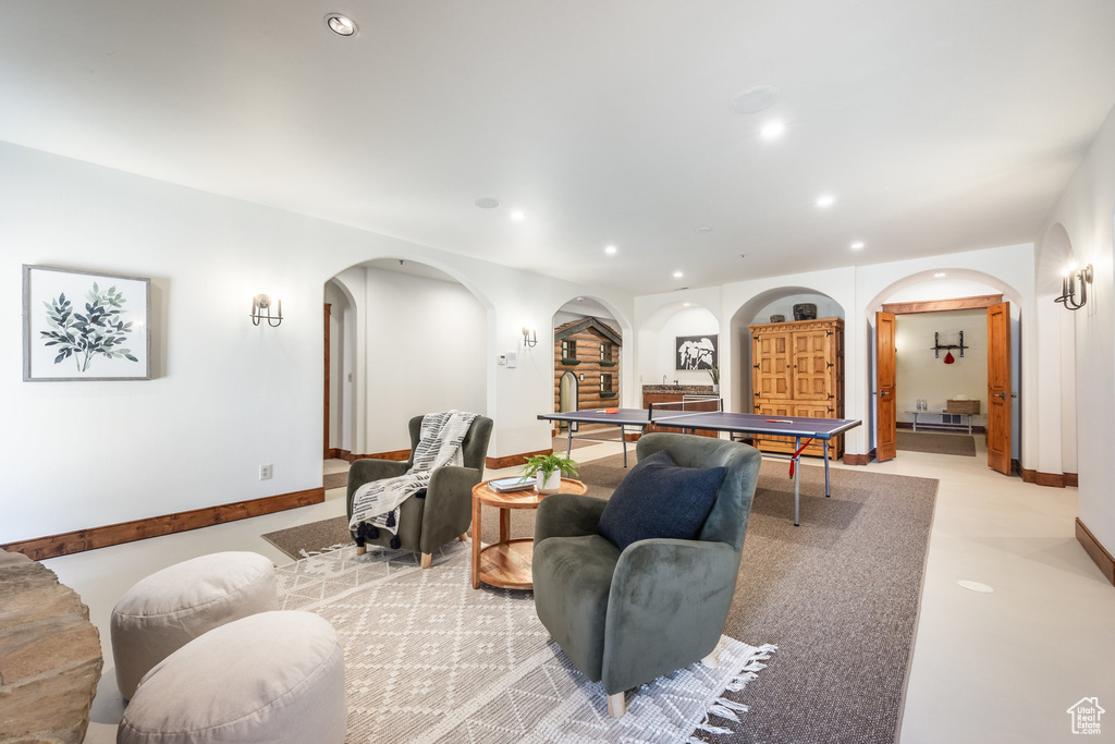 Living area with arched walkways, recessed lighting, and baseboards