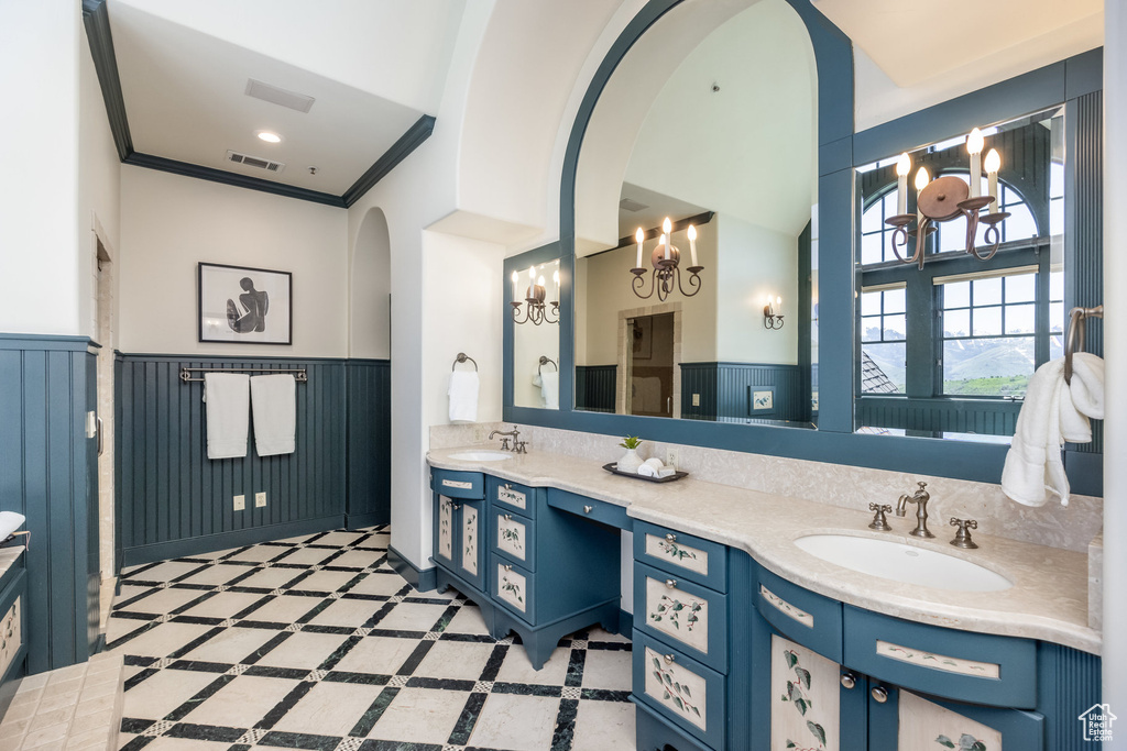 Full bathroom with wainscoting, double vanity, and inlaid floor details