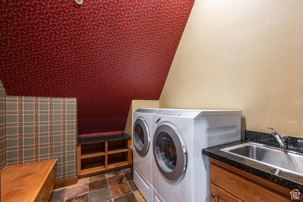Laundry area featuring separate washer and dryer, cabinet space, and stone finish floors