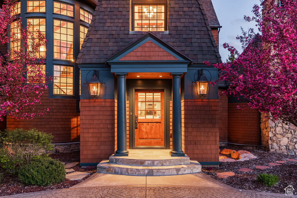 Entrance to property featuring a shingled roof