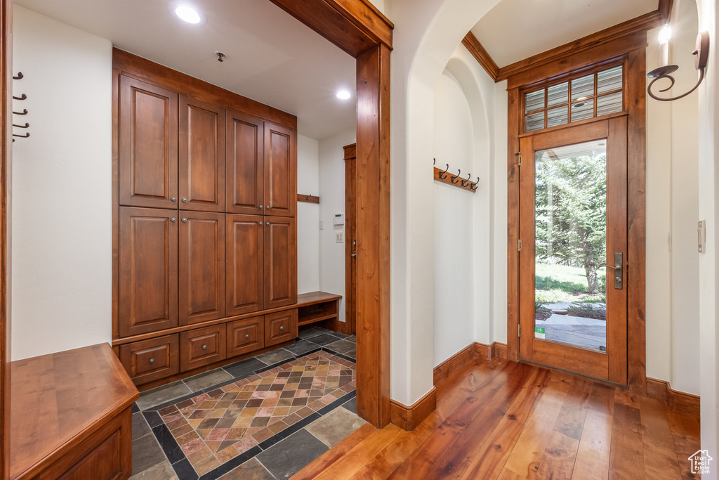 Foyer entrance featuring baseboards, recessed lighting, dark wood finished floors, and arched walkways