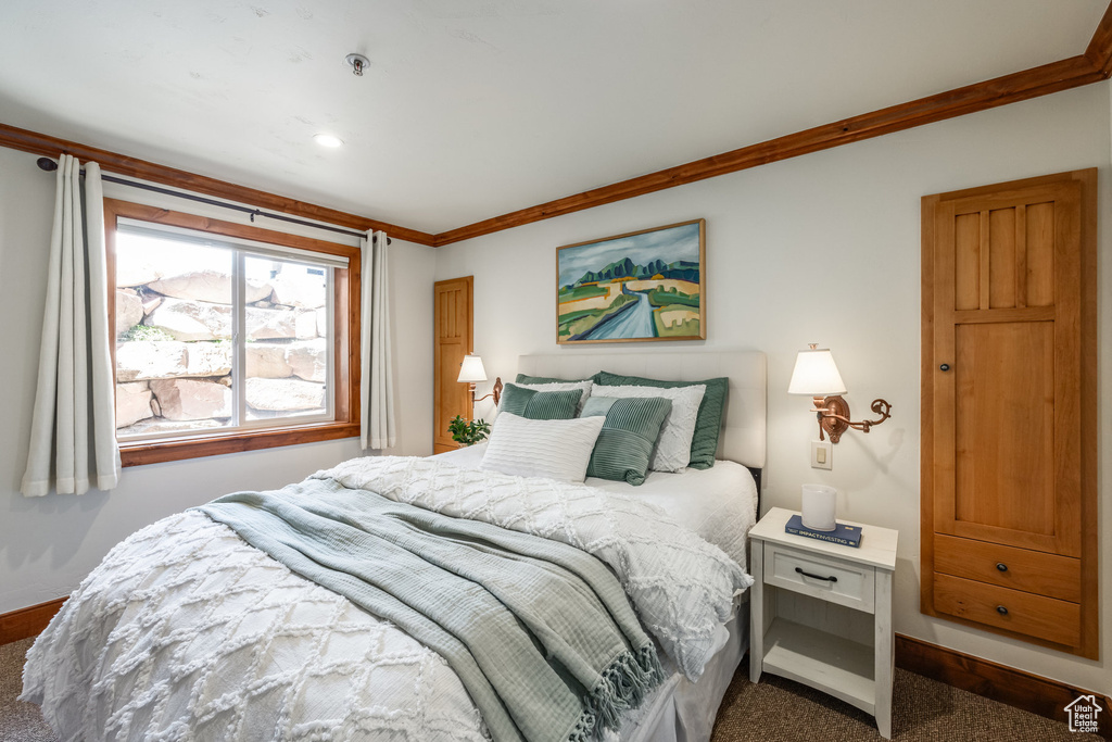 Bedroom with baseboards, carpet flooring, and ornamental molding
