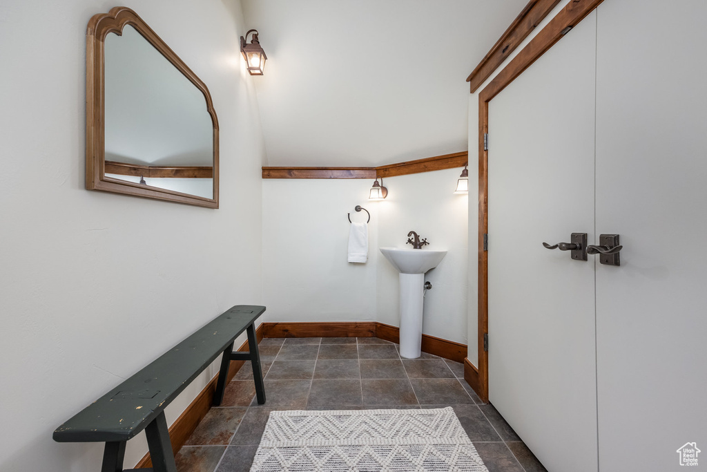 Bathroom with baseboards, a sink, and stone finish floors