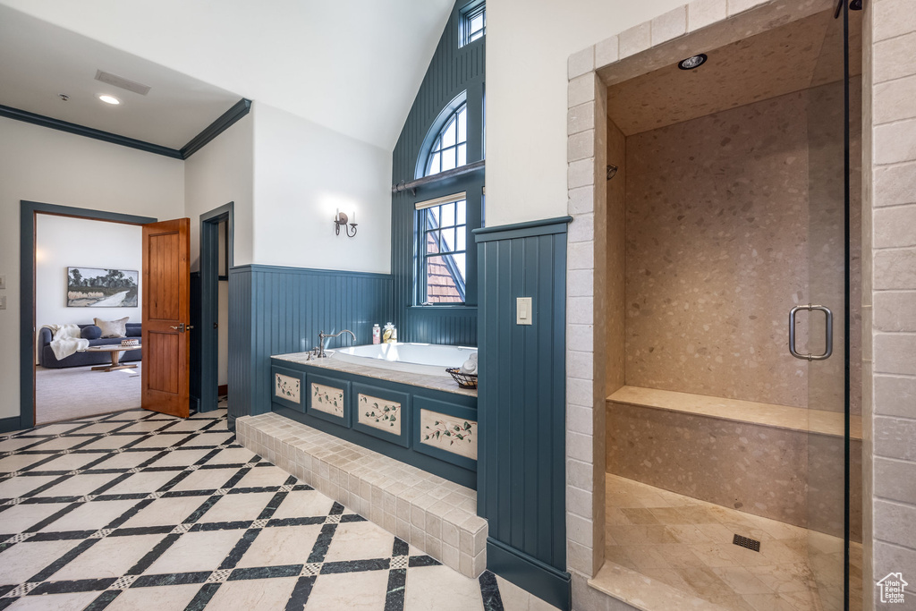 Bathroom featuring a garden tub, a shower stall, a wainscoted wall, and vaulted ceiling