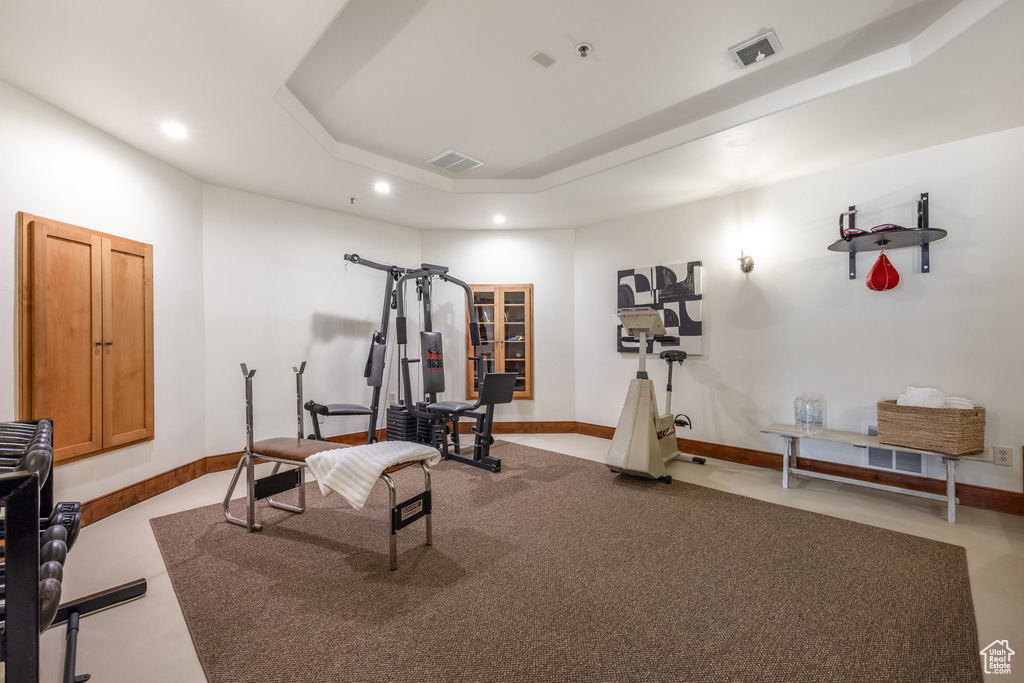 Workout area with a tray ceiling, recessed lighting, baseboards, and carpet