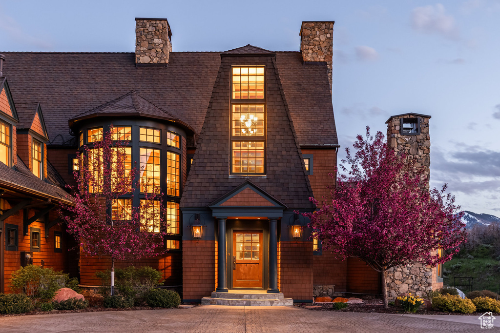 Shingle-style home featuring a chimney