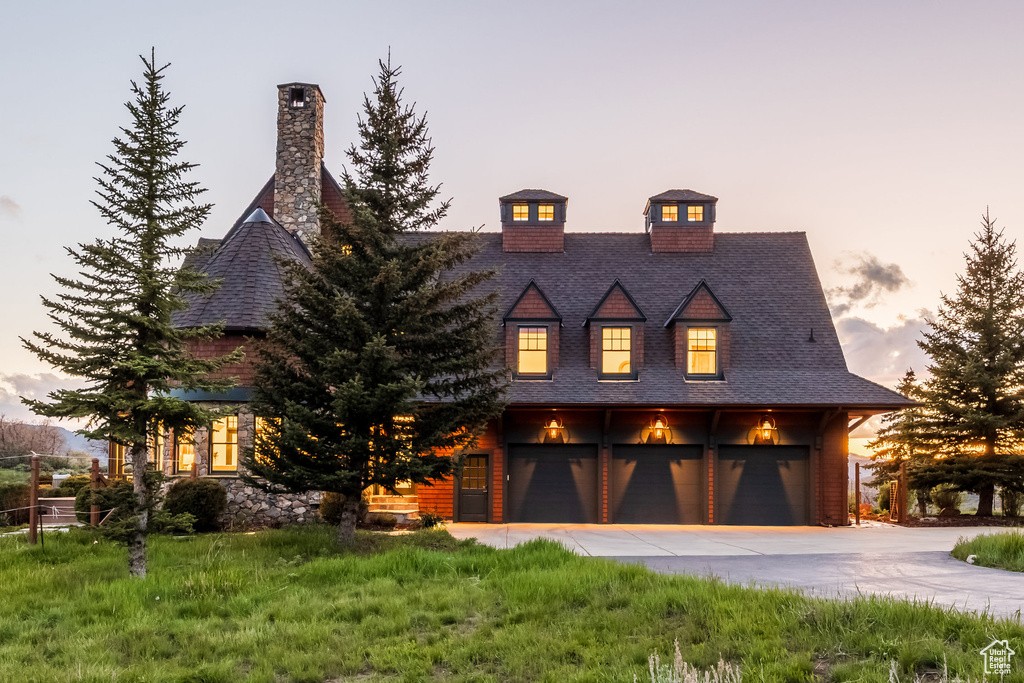 View of front of home with concrete driveway and a garage