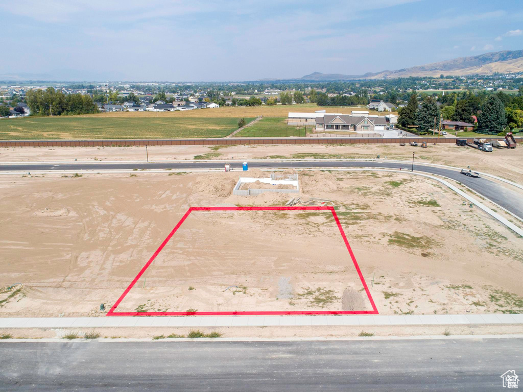 Aerial view of property and surrounding area with a mountainous background and property parcel outlined