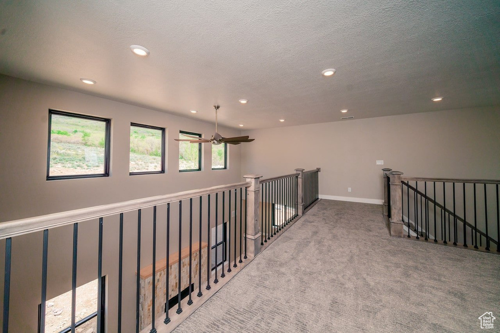 Hallway with an upstairs landing, recessed lighting, carpet floors, and a textured ceiling