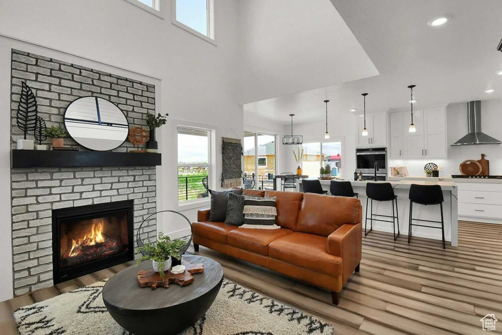 Living area with light wood finished floors, recessed lighting, and a brick fireplace