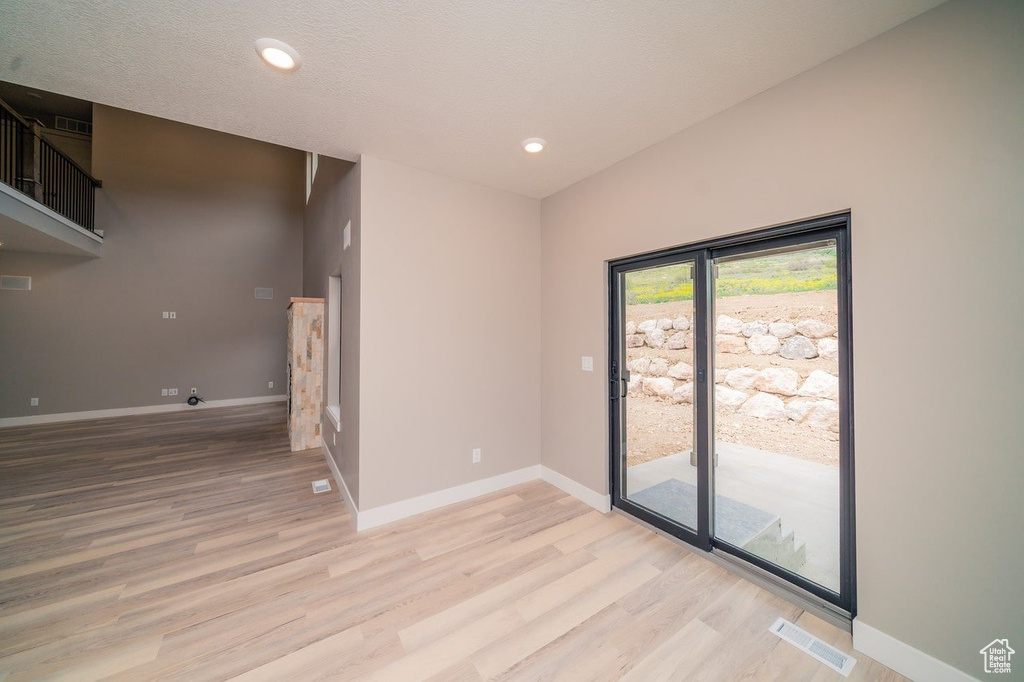 Empty room with light wood-type flooring, baseboards, and recessed lighting