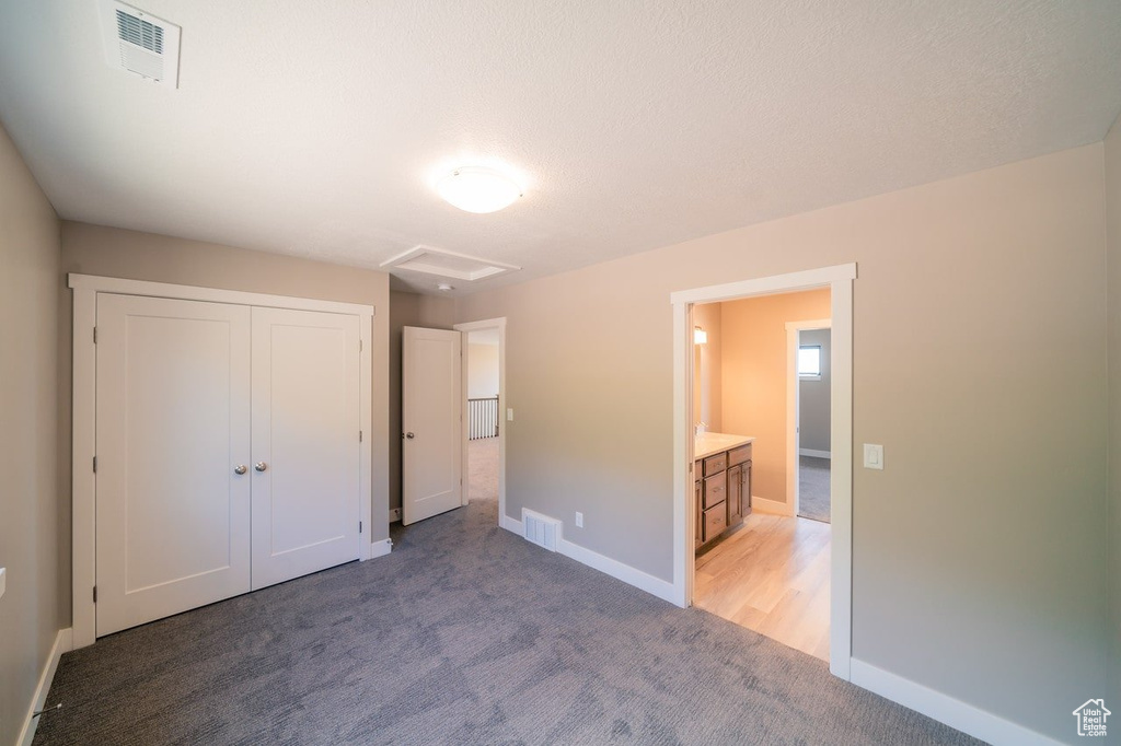 Unfurnished bedroom featuring light colored carpet, baseboards, and a closet