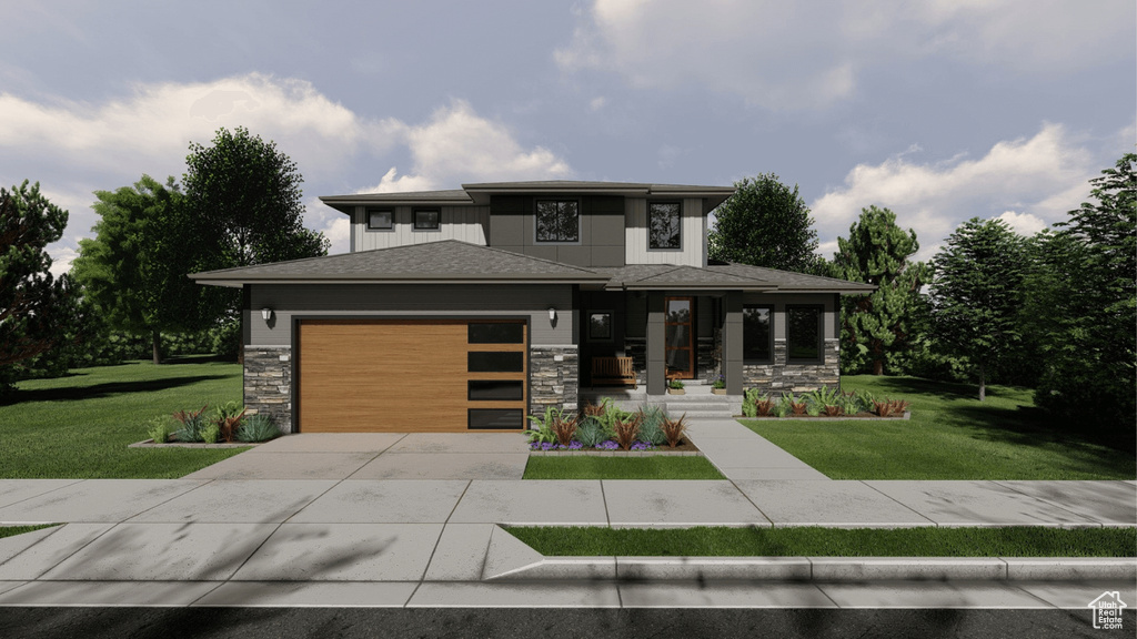 Prairie-style home with stone siding, concrete driveway, a garage, and a front yard