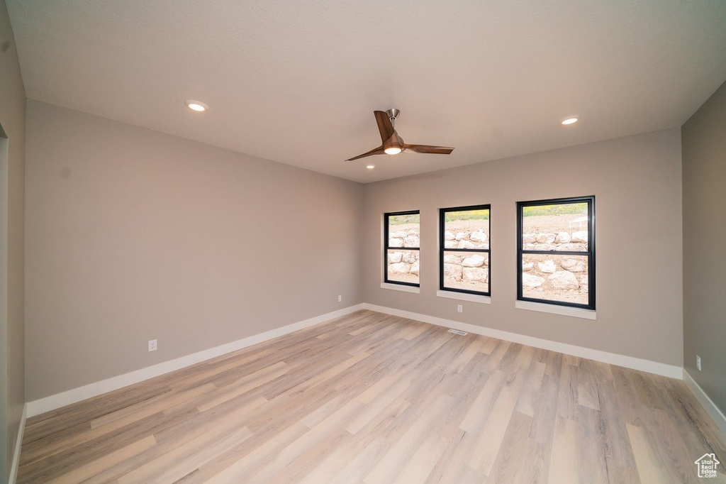 Empty room featuring ceiling fan, light wood-style floors, recessed lighting, and baseboards