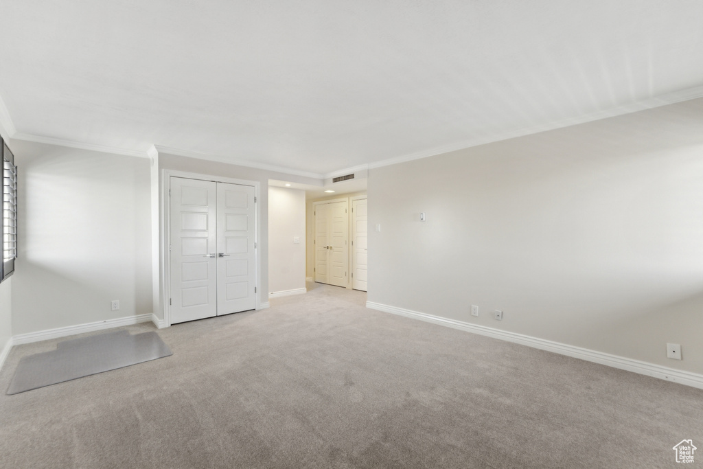 Unfurnished bedroom featuring crown molding, carpet flooring, and baseboards