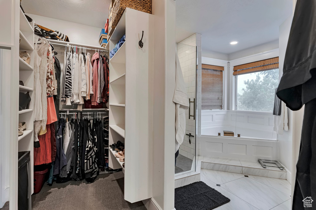 Full bath featuring a spacious closet, a bath, a stall shower, and recessed lighting