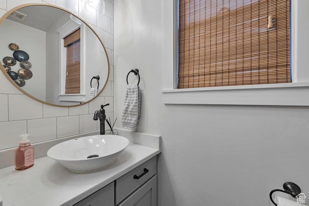 Bathroom featuring decorative backsplash and vanity