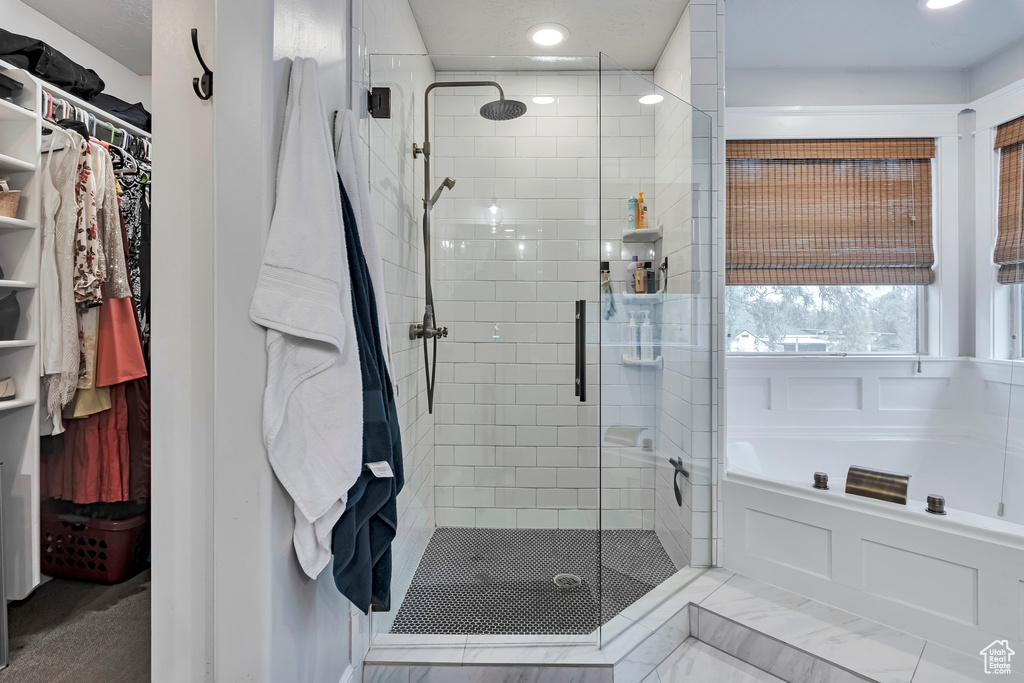 Bathroom with a shower stall, a bath, a walk in closet, and recessed lighting