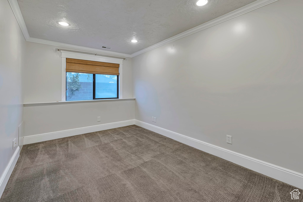 Carpeted empty room featuring ornamental molding, baseboards, recessed lighting, and a textured ceiling